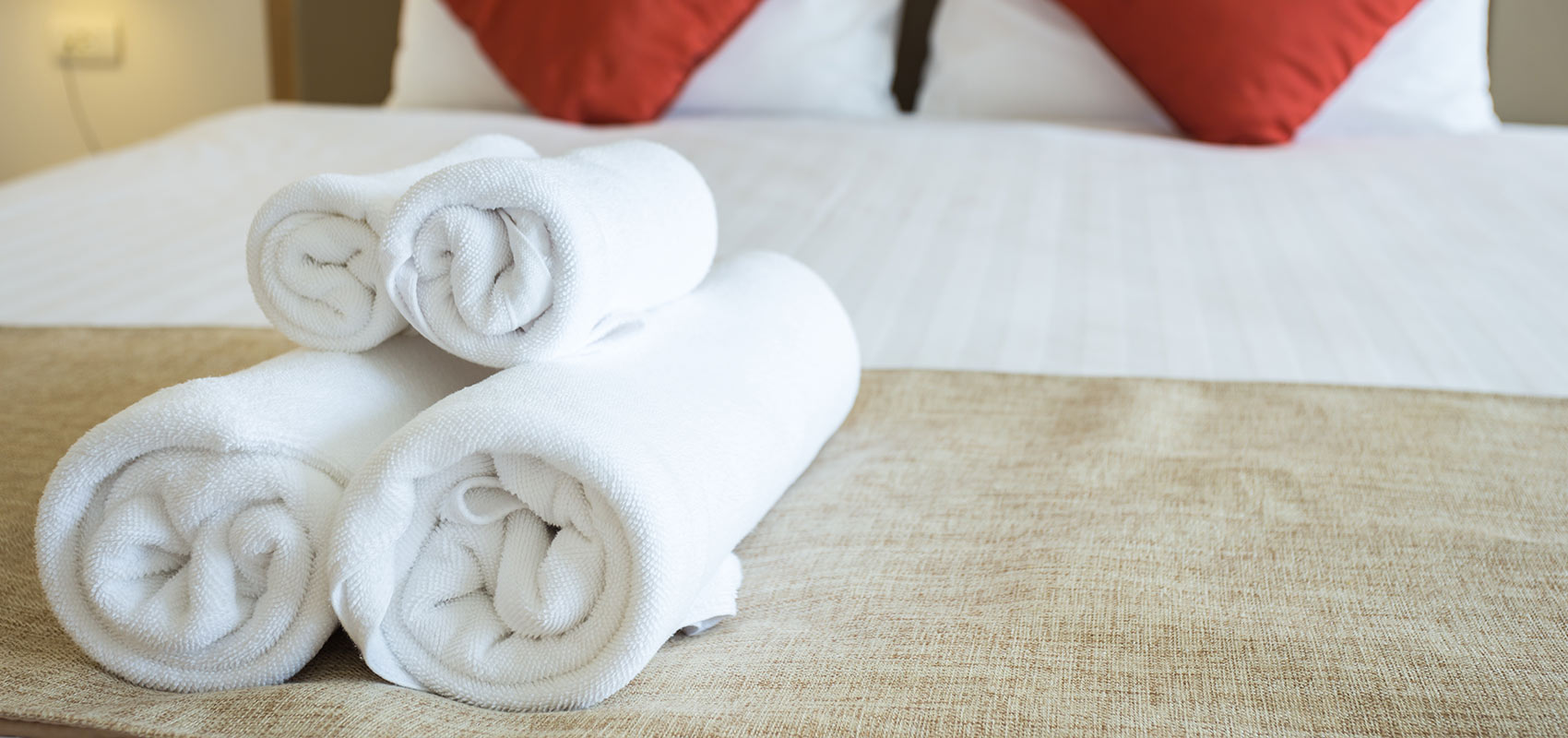 Towels rolled up on a bed